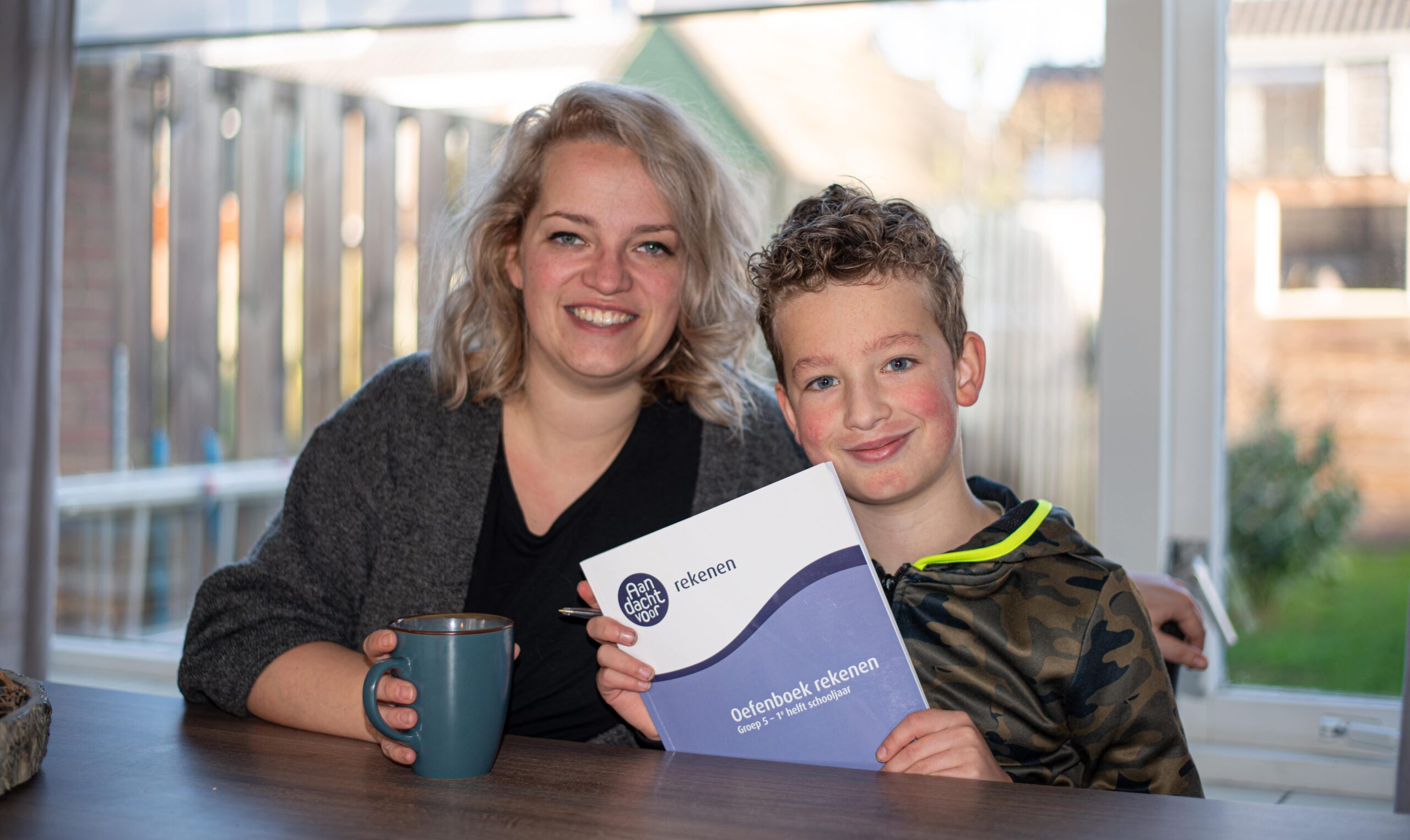 Moeder en zoon met oefenboek rekenen