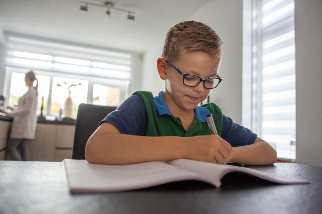 jongetje schrijft in schrift