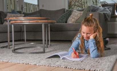 Meisje schrijft op de grond in boek