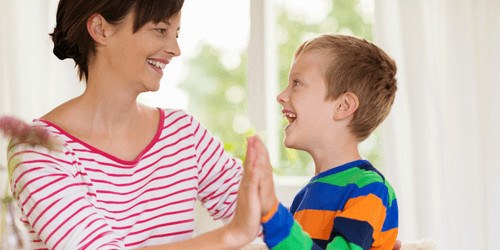 jongetje en moeder geven high five