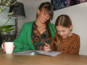 moeder met dochter aan het werk in oefenboek