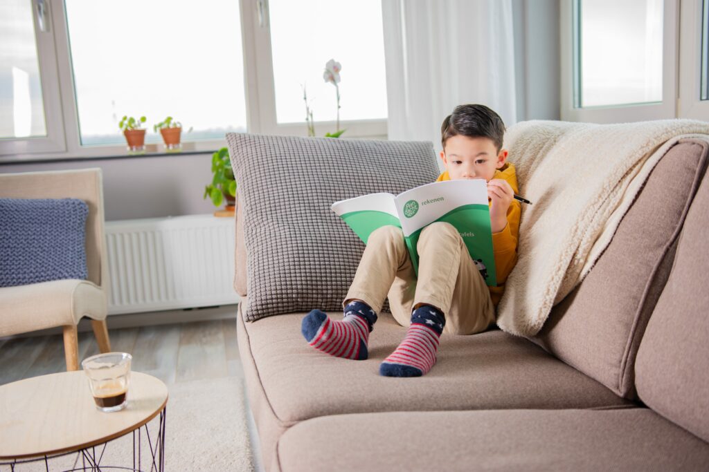 jongetje oefent rekenen op de bank