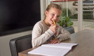 meisje met pen en oefenboek