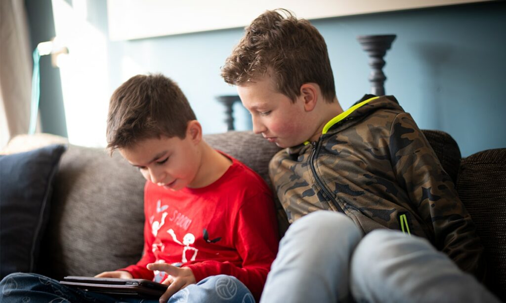 twee jongens op bank met ipad