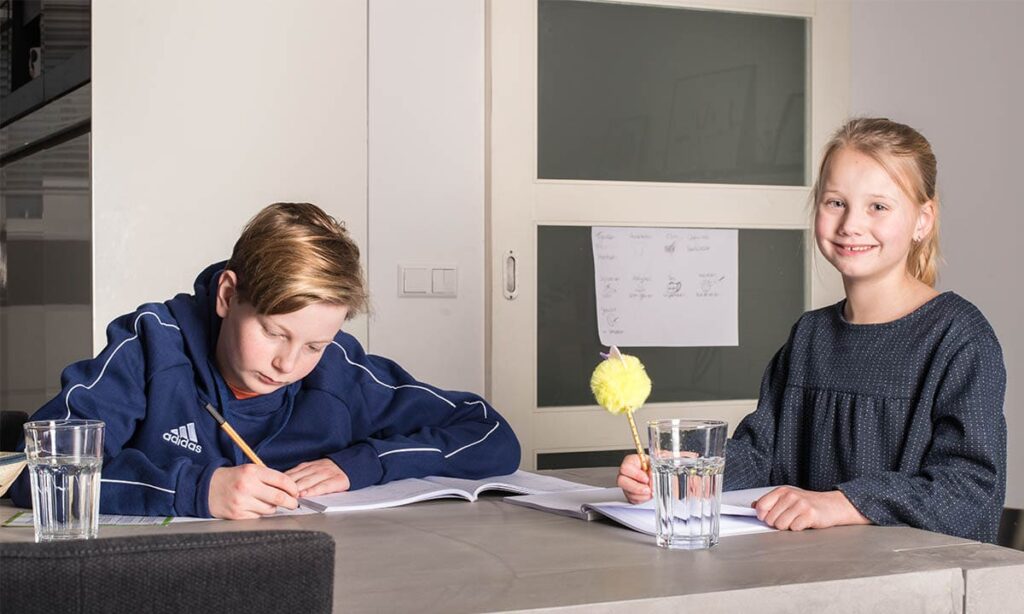 broer en zus maken huiswerk keukentafel