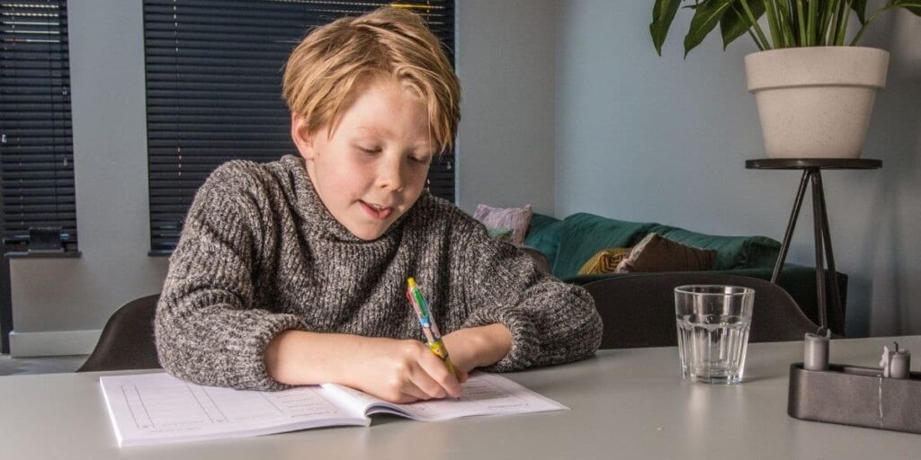 jongen schrijft in boek