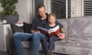 vader dochter op de bank met werkboek rekenen