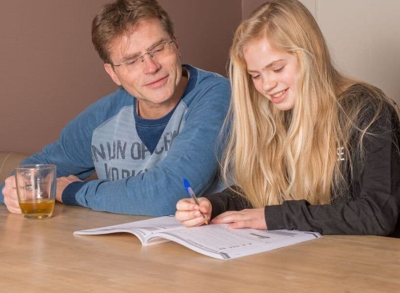 vader en dochter oefenen aan de tafel