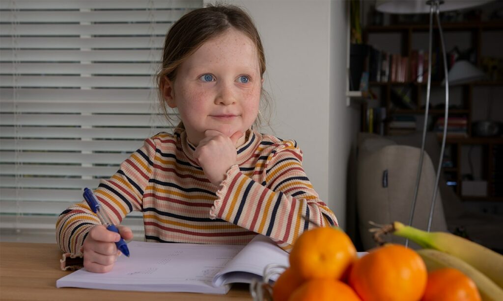 Meisje denkt na over opdracht in werkboek
