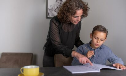 moeder helpt zoon met opdrachten werkboek