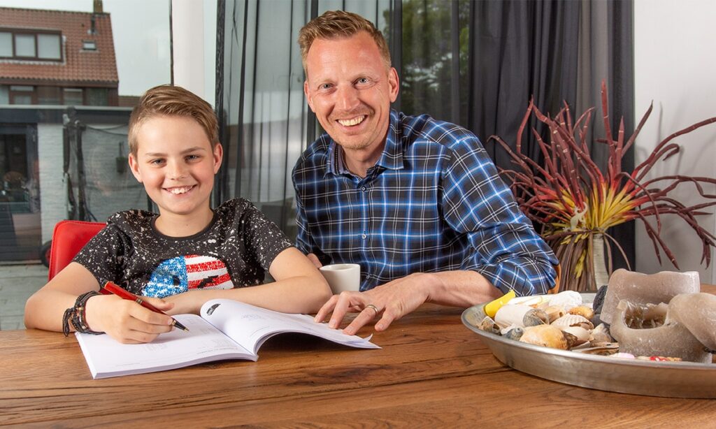 vader helpt zoon met huiswerk