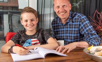 vader helpt zoon met huiswerk