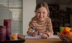 Meisje aan tafel met pen en werkboek