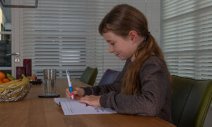 meisje maakt oefenopdrachten in werkboek