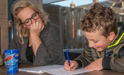 moeder helpt zoon met oefeningen in werkboek