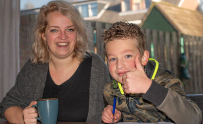 moeder helpt zoon met schoolopdrachten aan tafel