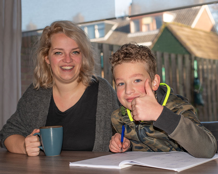 moeder helpt zoon met schoolopdrachten aan tafel
