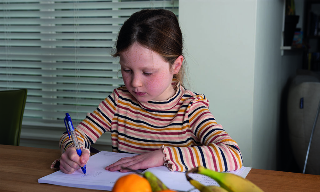 meisje maakt oefenopdrachten in boek