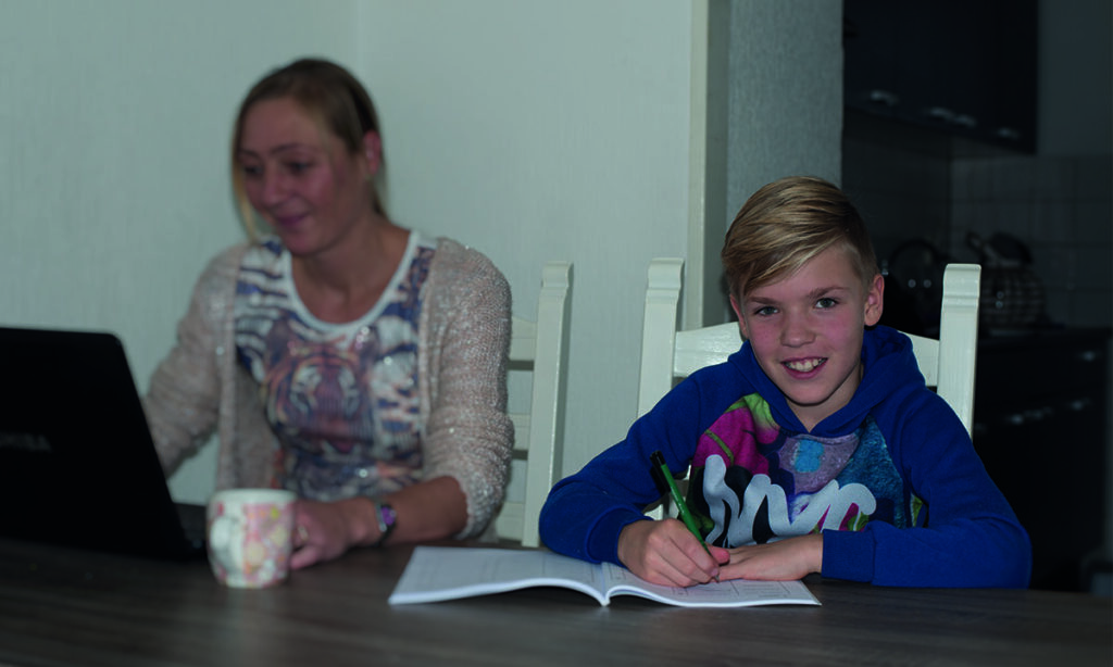 moeder en zoon werken aan tafel aan schoolopdrachten