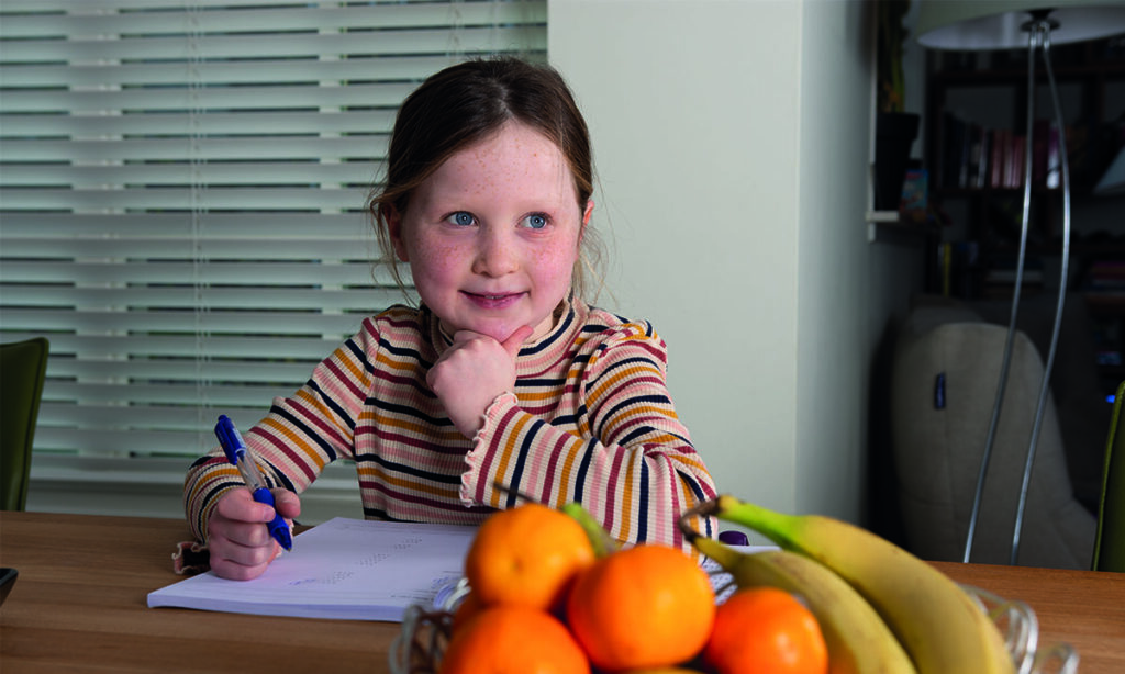 basisschoolleerling maakt opdrachten aan de keukentafel