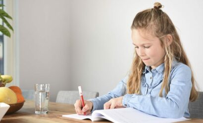 meisje ijverig aan het werk in werkboek aan tafel
