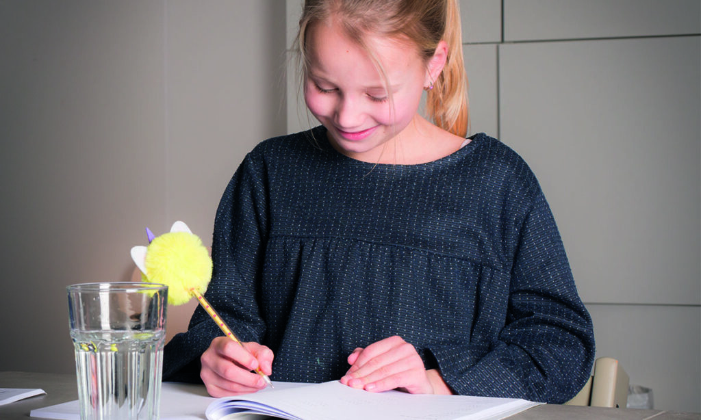 meisje maakt opdracht in werkboek met pen