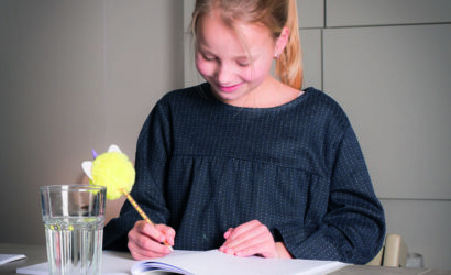 meisje maakt opdracht in werkboek met pen