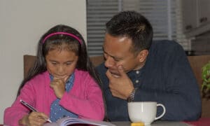 vader helpt dochter met oefenopdrachten