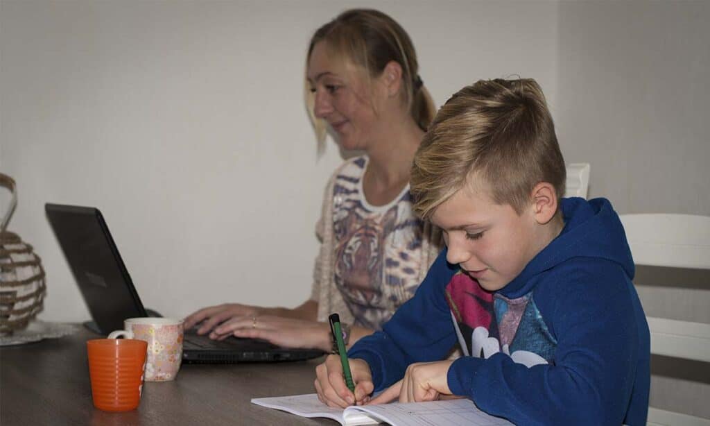 moeder en zoon werken samen aan de keukentafel