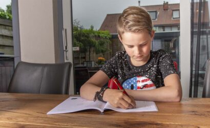 jongen maakt opdrachten aan tafel in werkboek