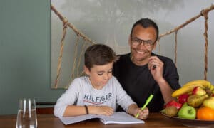 vader helpt zoon met schoolwerk