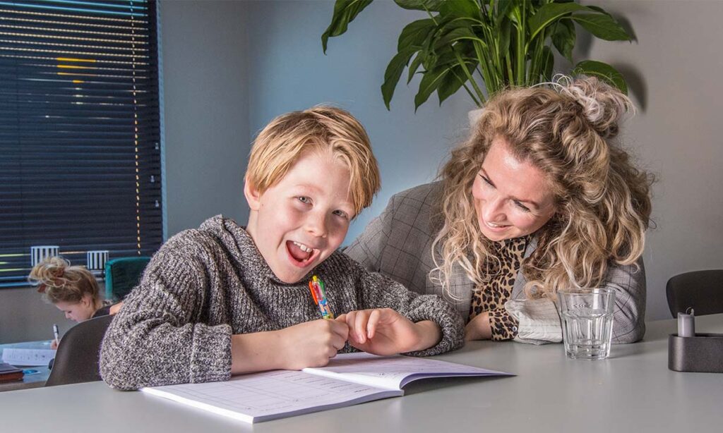 vrouw en jongen aan tafel met meisje op de achtergrond